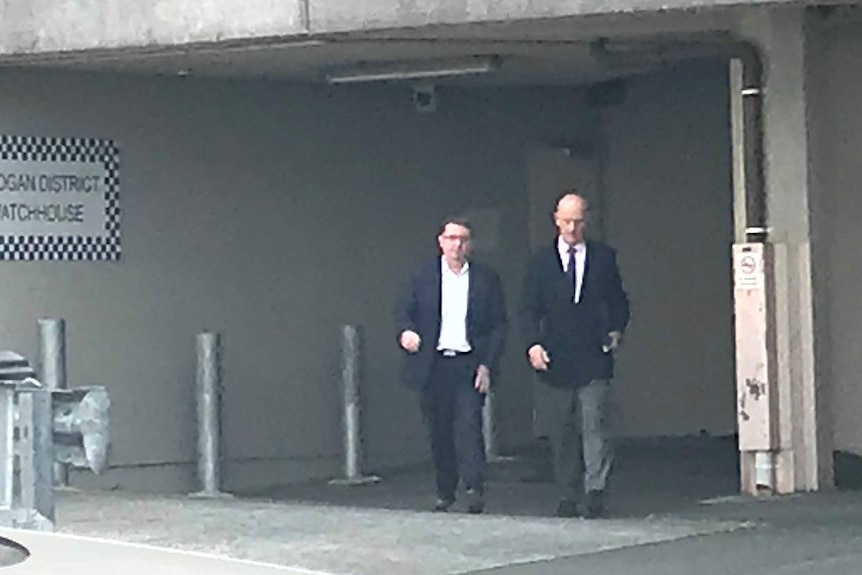 Luke Smith and another man leaving Logan police watch house