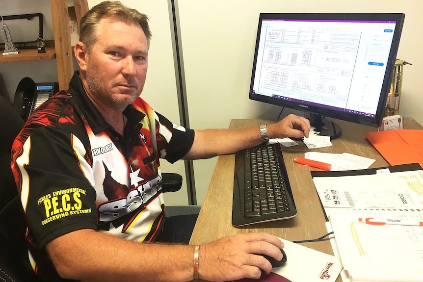 CFMMEU mining and energy safety inspector Jason Hill sits at a desk with a computer.