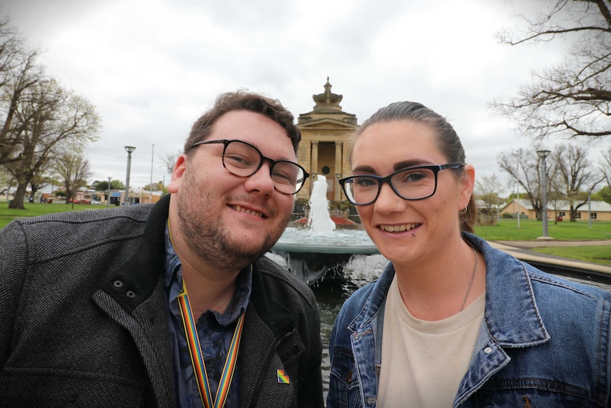 Jarrad Mee and Sarah White sit, smiling, in Colac's Memorial Square
