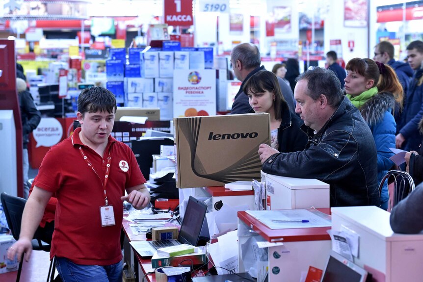 A man holds a laptop in a mall in central Moscow
