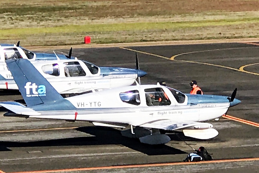 Safety inspectors check an aircraft on the tarmac.