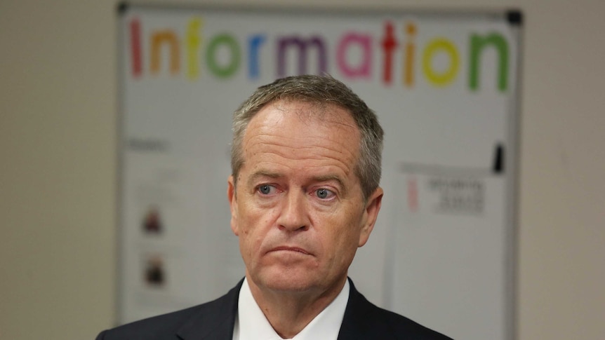 Bill Shorten looks ahead as the word "information" hovers above his head in a childcare centre