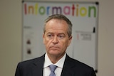 Bill Shorten looks ahead as the word "information" hovers above his head in a childcare centre