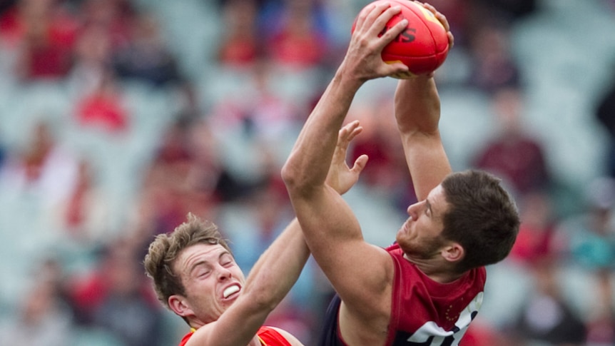 The Demons' Jeremy Howe takes a big mark over the Sun's Tom Lynch at the MCG.