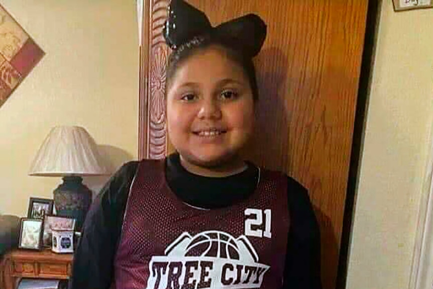 Close up of a young girl in her basketball uniform, smi