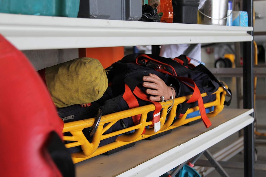 A training dummy lays on an aeromedical evacuation bed.