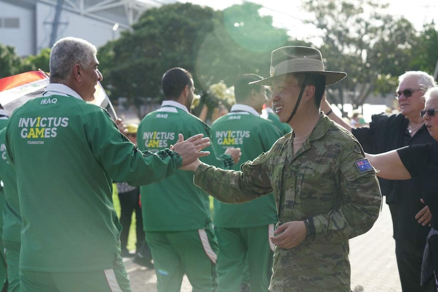 Iraq athletes high fiving an Australian army officer