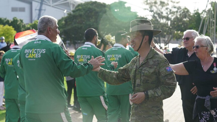 Iraq athletes high fiving an Australian army officer