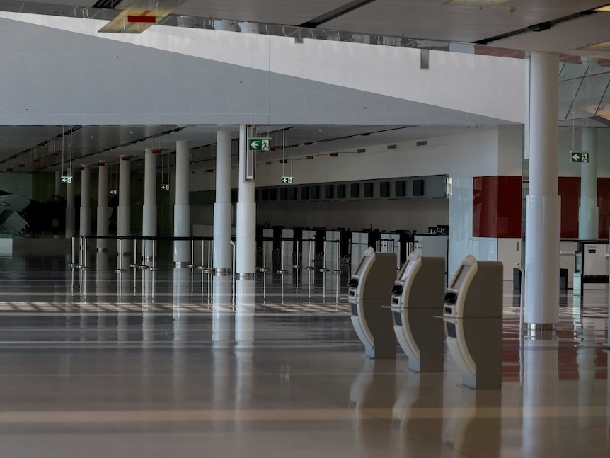 Unattended check-in desks and self check-in machines in a dark airport terminal