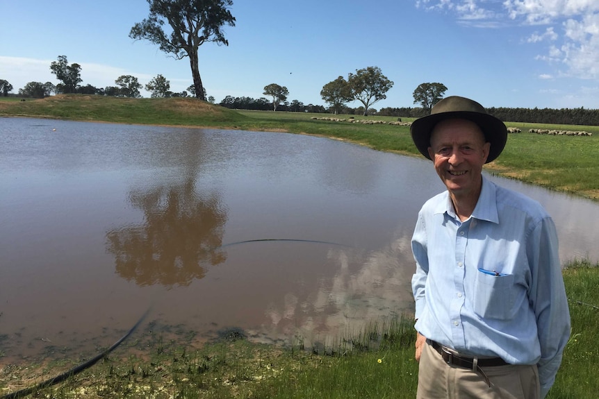 Dergholm farming veteran Murray Davis stands next to his large dam.