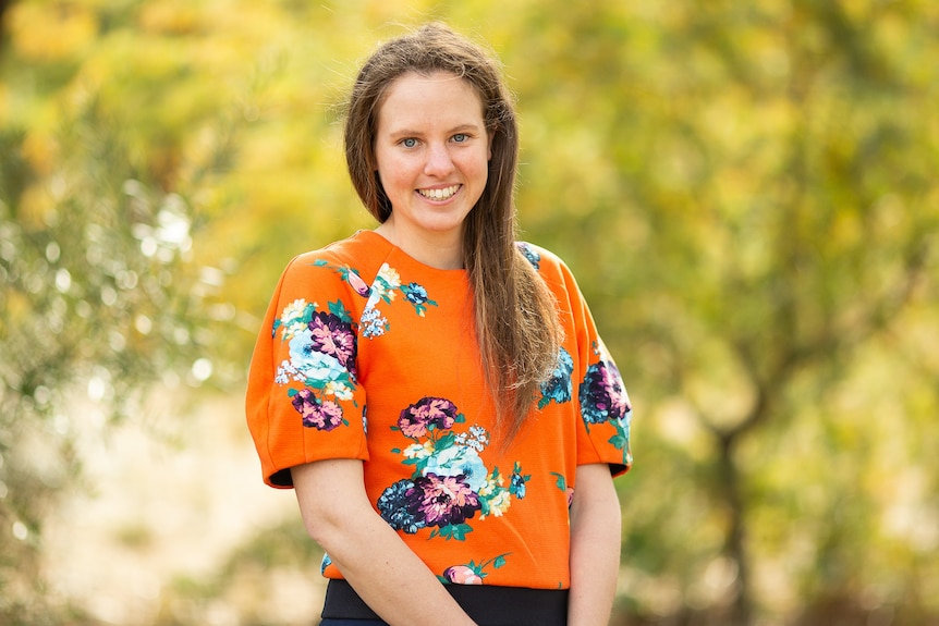 A woman in an orange floral top.