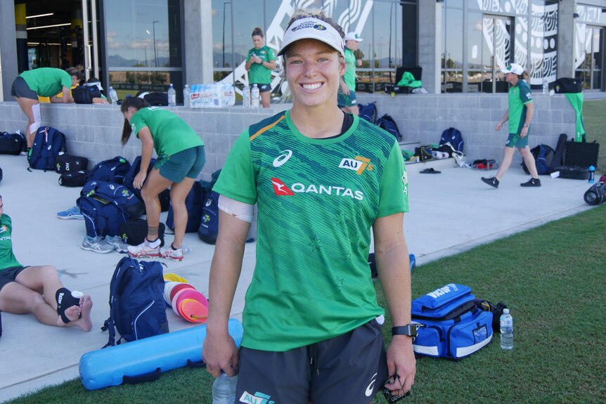 Young lady in a green shirt smiling.