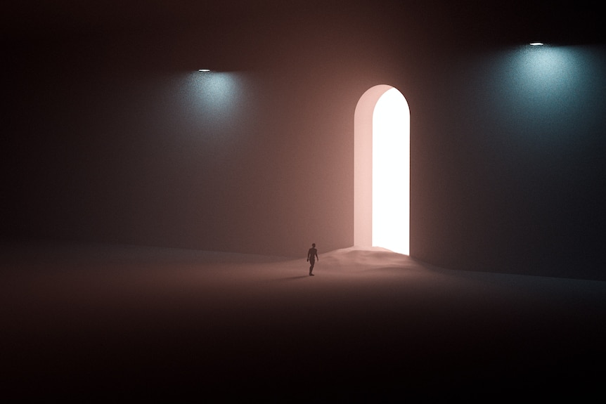 A person walking on sand towards a tall door with light coming out of it