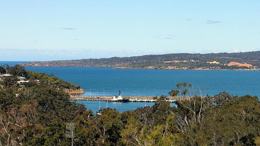 View across Twofold Bay from the Snug Cove wharves across to the Navy wharf and chip mill