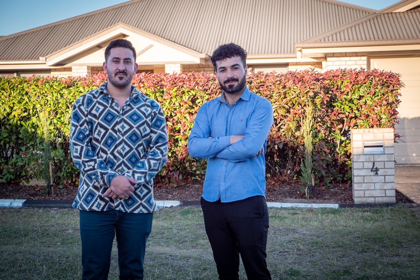 Support worker Nayif Rasho and Anas Khalaf standing on the street outside a house in Toowoomba, June 2023.