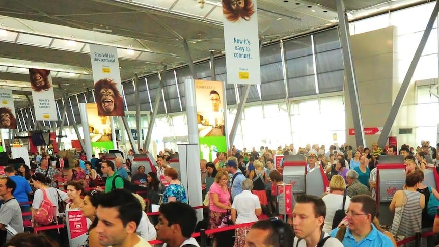 Virgin Blue passengers queue at the check-in counters at Sydney Airport