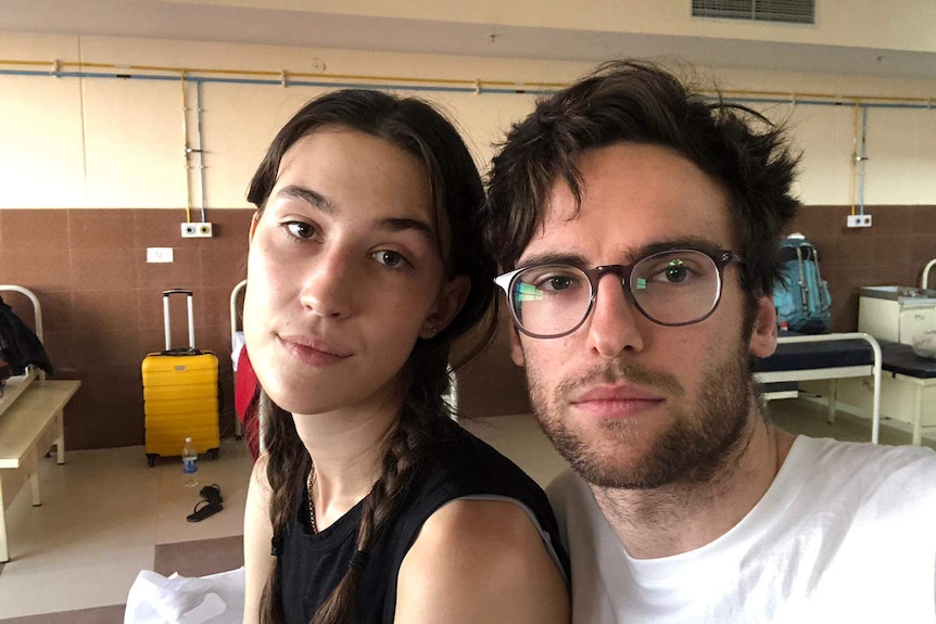 A young couple looking solemn on a hospital bed