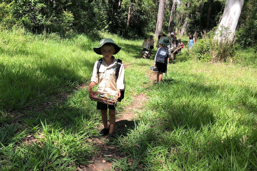 Students walk along a bush track.