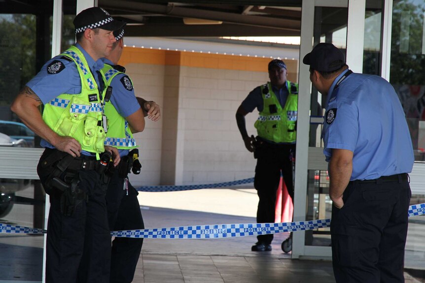 Police stand guard outside the South Hedland shopping centre.