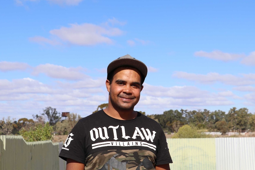 Keith Dutton from The Wilcannia Mob in front of a blue sky background.