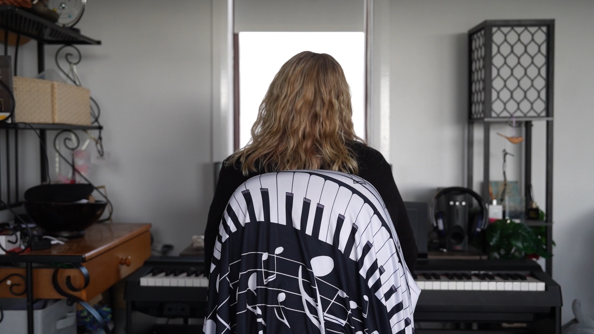 A woman sits at a piano