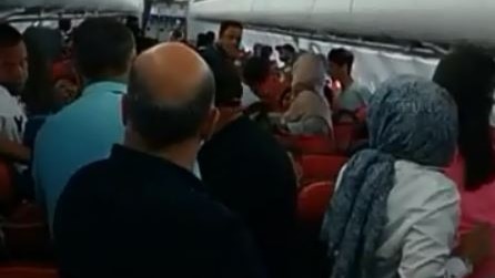 People stand up on a flight from Sweden.