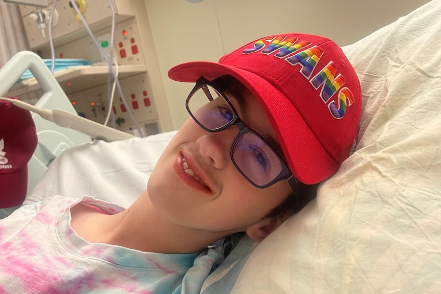 Ateenager in hospital wearing a red hat