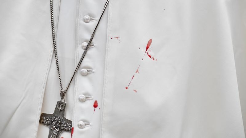 A few droplets of blood stain Pope Francis' white tunic