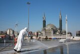 Workers clean and disinfect surfaces in front of a mosque in Istanbul's iconic Taksim Square.