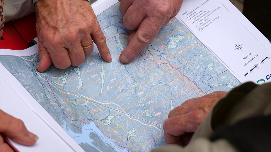 Hands point to sections of a map of Cordeaux Dam catchment area.