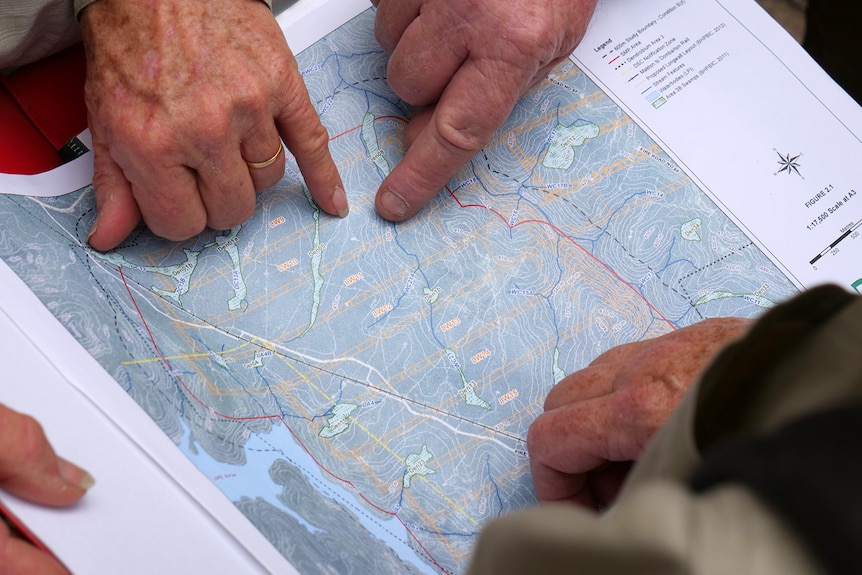 Hands point to sections of a map of Cordeaux Dam catchment area.