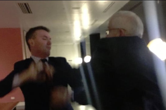 James Ashby and former One Nation senator Brian Burston scuffle in a grainy image.