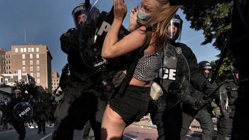 Riot police rush demonstrators as they clear Lafayette Park.