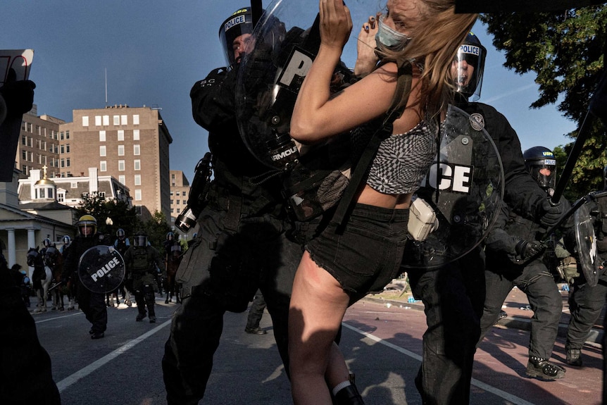 Riot police rush demonstrators as they clear Lafayette Park.