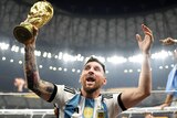 Argentina's Lionel Messi holds the FIFA World Cup as his teammates lift him on their shoulders after the final in Qatar.