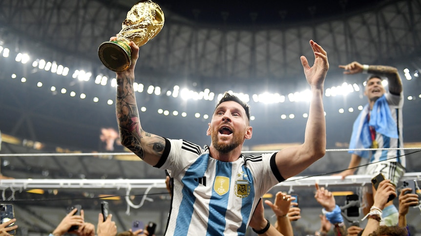 Argentina's Lionel Messi holds the FIFA World Cup as his teammates lift him on their shoulders after the final in Qatar.