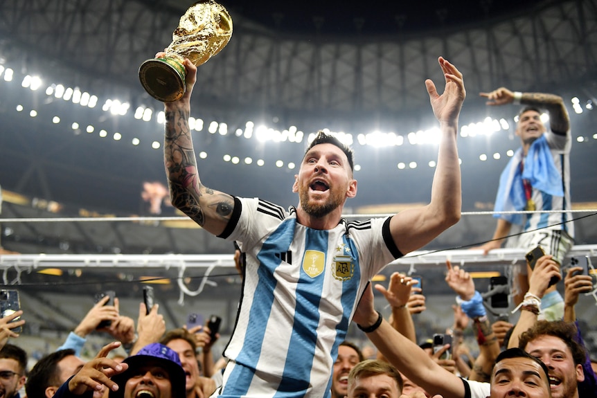 Argentina's Lionel Messi holds the FIFA World Cup as his teammates lift him on their shoulders after the final in Qatar.