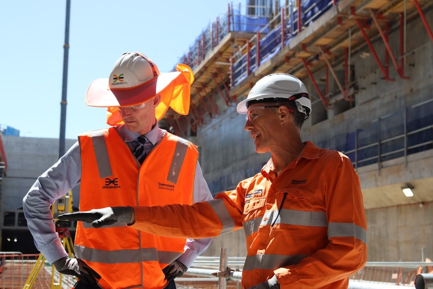 Queensland's Transport Minister Mark Bailey with a worker on a construction site wearing high-vis