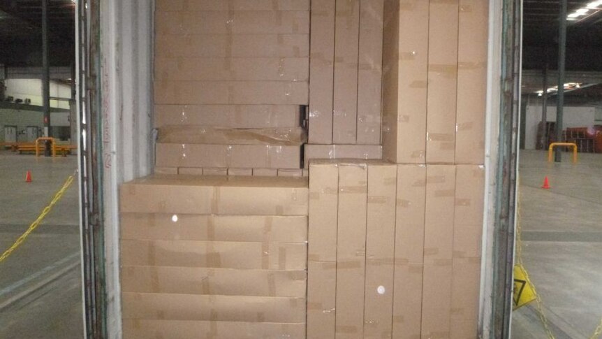 Kotak rokok disembunyikan di balik kotak-kotak lain yang berisi panel-panel plastik.