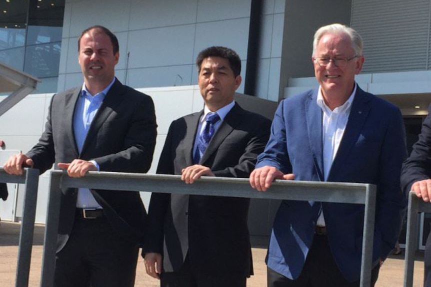 Three men standing in front of a building in Darwin.