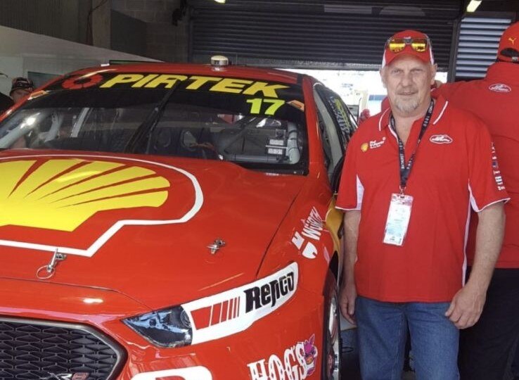 Graham Dawson standing next to a racecar.