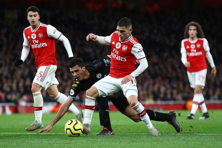 Two English Premier League players challenge for the ball during a match in London.