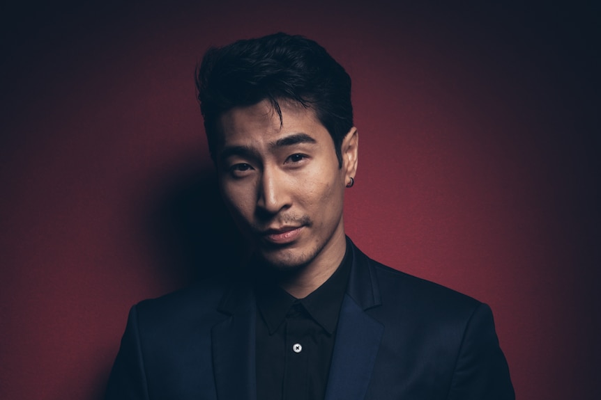 The actor Chris Pang in a blue suit, red background