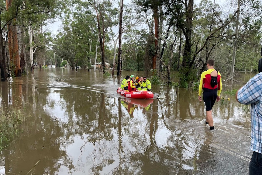 Un sale sur les eaux de crue avec plusieurs volontaires au milieu des arbres