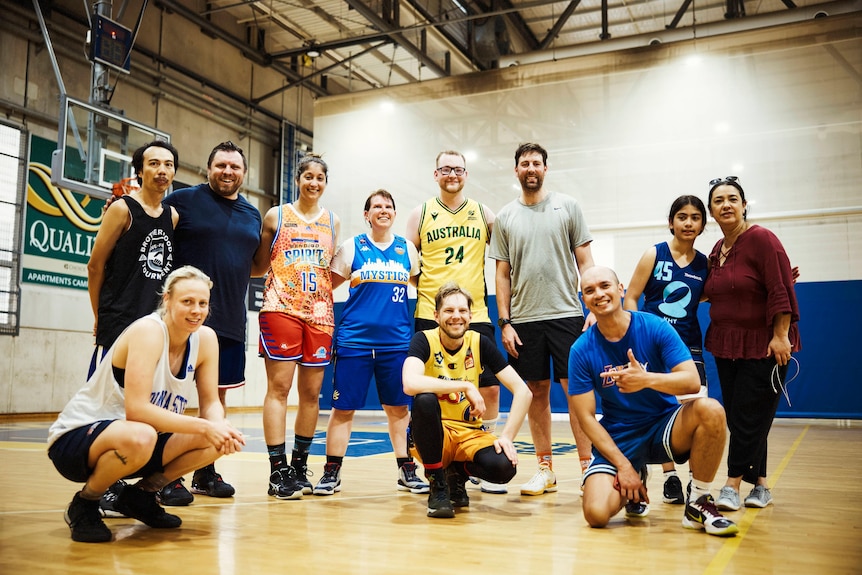 A team photo of casual basketballers looking at the camera and smiling.