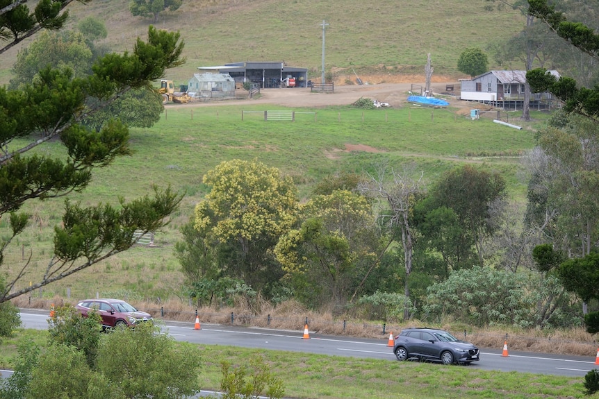 A rural property in the background and a highway in the foreground.