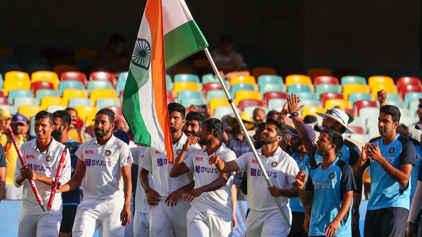 Indian cricketers carry the national flag as they walk around the Gabba after the last Test against Australia.