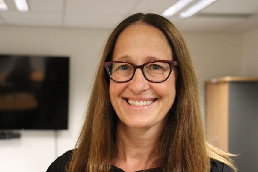 Tête d'une femme souriante portant des lunettes