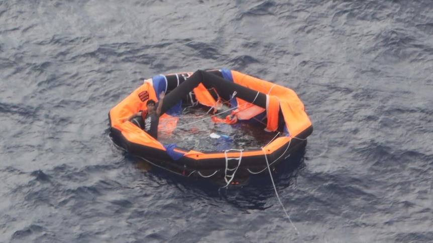 A sailor from the Livestock 1 vessel, which is believed to have sunk in waters off Japan, waves to a rescue aircraft crew.