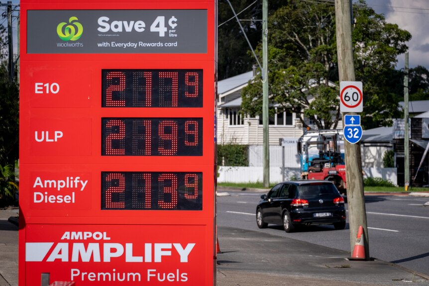 A petrol price sign reads prices near two dollars and twenty cents. 